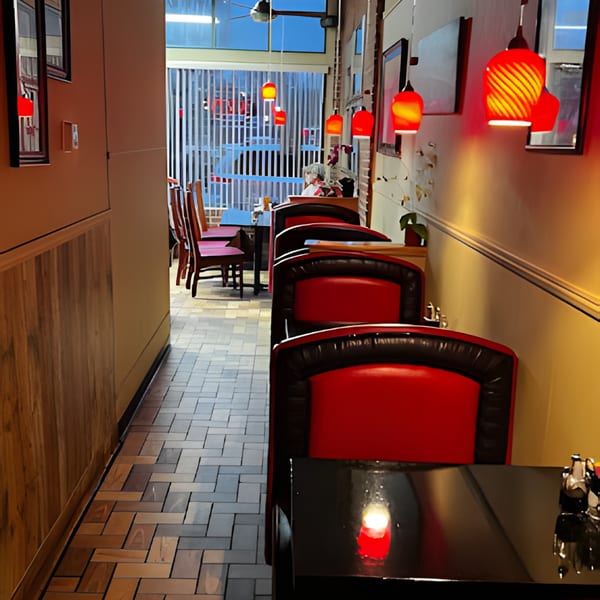Interior of Bao Bao Chinese Bistro with red booths, dark tables, and red pendant lights.