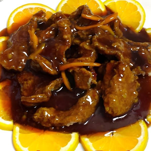 Bao Bao Chinese Bistro's orange chicken, glistening with sauce and garnished with fresh orange slices.